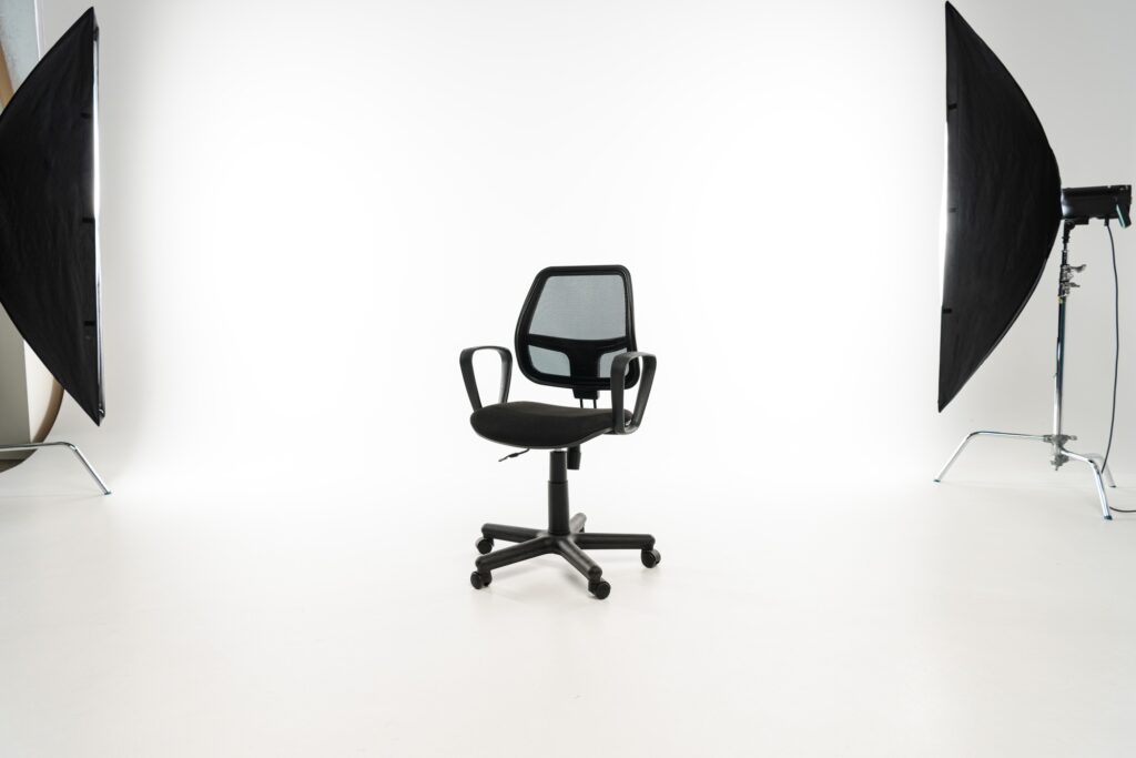 Black office chair with studio light on white background