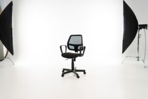Black office chair with studio light on white background