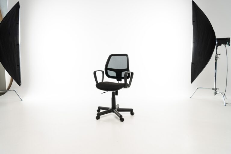 Black office chair with studio light on white background