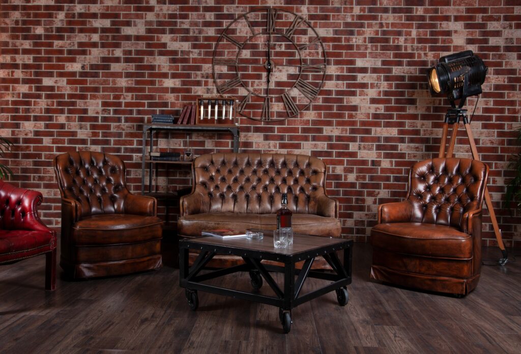 Leather sofa and armchair in the office. Coffee table in the library. Room interior. Old vintage