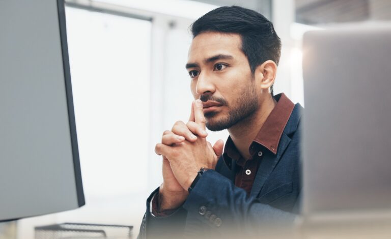 Office, concentration and face man at computer thinking or brainstorming ideas for online project.